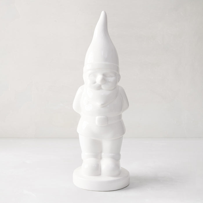 White ceramic holiday gnome with a tall, pointed hat and creamy white glaze.