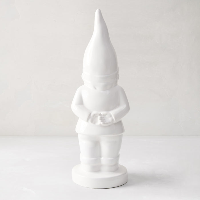 White ceramic holiday gnome with a tall, pointed hat and creamy white glaze.