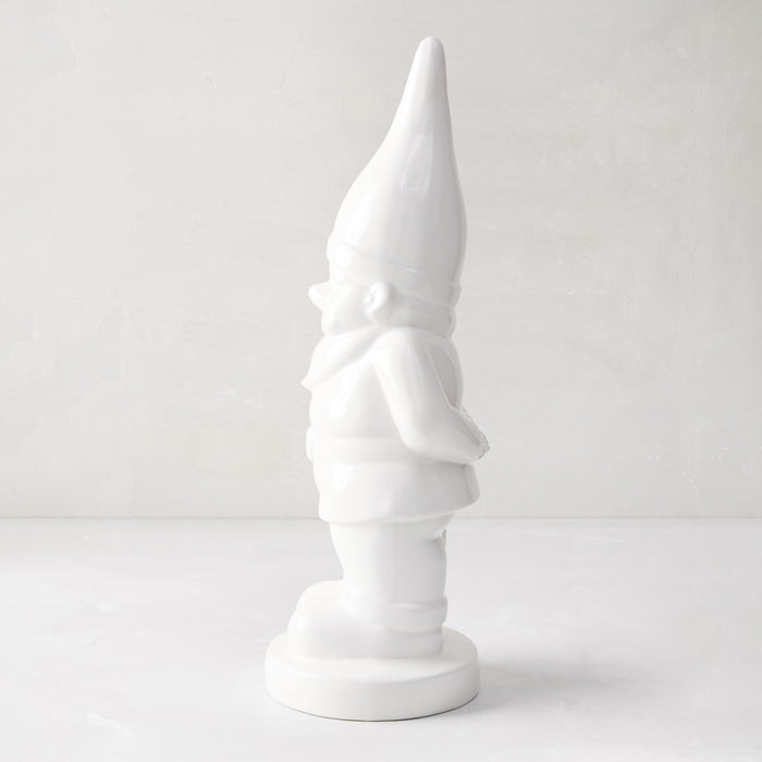 White ceramic holiday gnome with a tall, pointed hat and creamy white glaze.