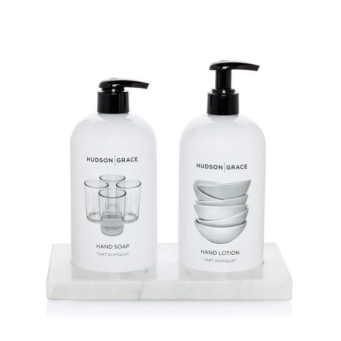 White marble tray holding two Hudson Grace hand soap and lotion bottles.