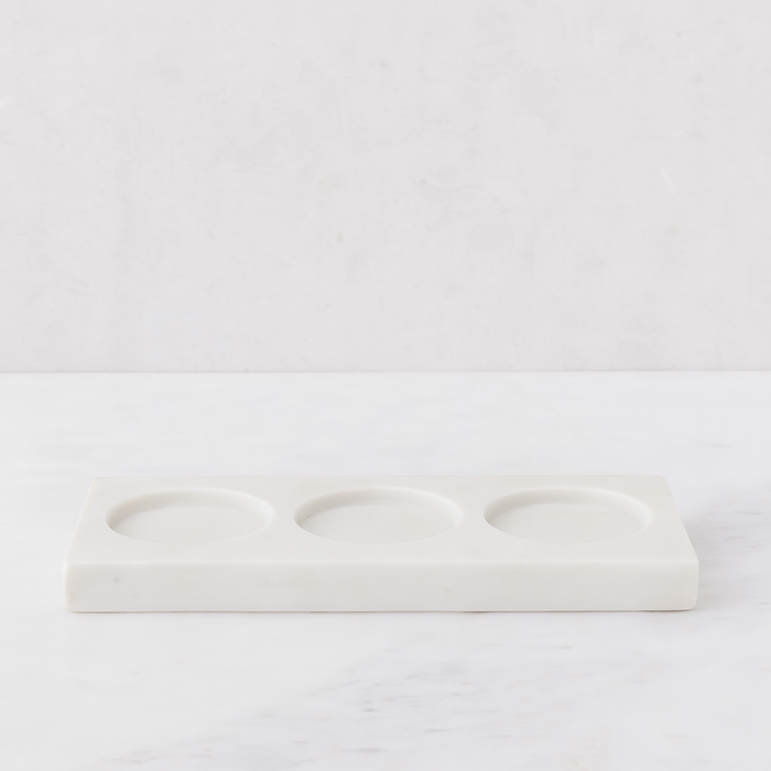 White marble triple soap and lotion tray with three circular indentations.
