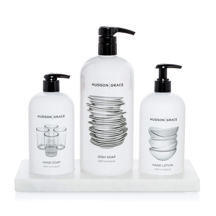 White marble triple soap and lotion tray holding three white Hudson Grace bottles.